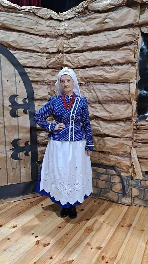 Starsza kobieta ubrana w góralski strój ludowy.