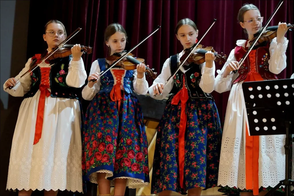 Występ muzyczny na skrzypcach czterech dziewcząt ubranych w stroje ludowe górale dorzecza soły.